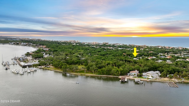 aerial view at dusk featuring a water view