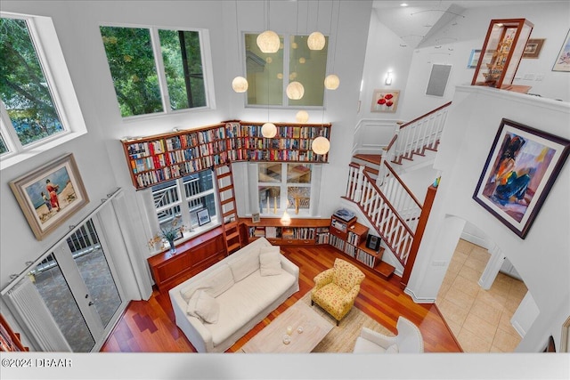 living room with a towering ceiling, plenty of natural light, and light hardwood / wood-style floors