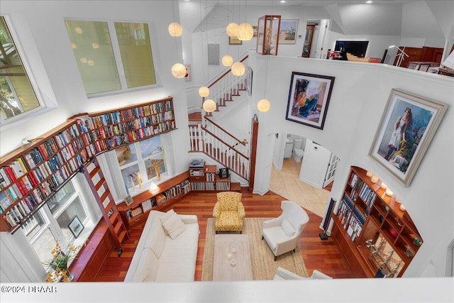 living room with wood-type flooring and a towering ceiling