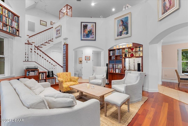 living room with ornamental molding, hardwood / wood-style floors, and a high ceiling