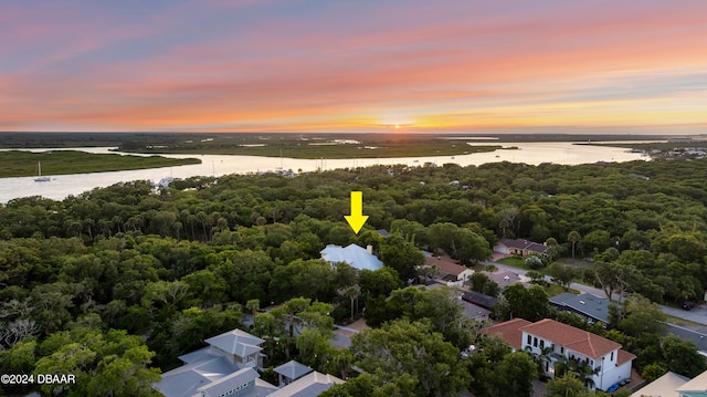 aerial view at dusk featuring a water view