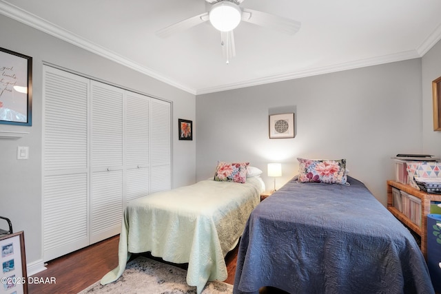 bedroom with crown molding, dark hardwood / wood-style floors, ceiling fan, and a closet