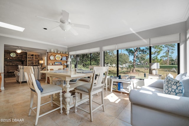 sunroom featuring ceiling fan, a healthy amount of sunlight, and a fireplace