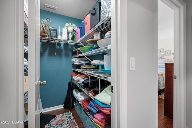 walk in closet with hardwood / wood-style flooring