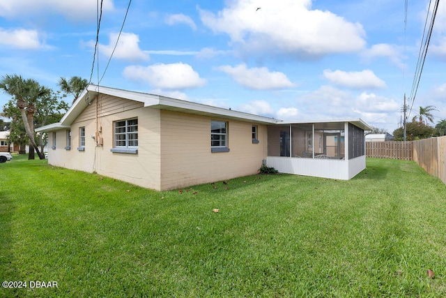 back of property featuring a sunroom and a yard