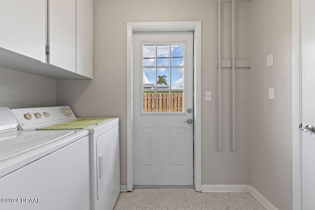 clothes washing area with cabinets and independent washer and dryer