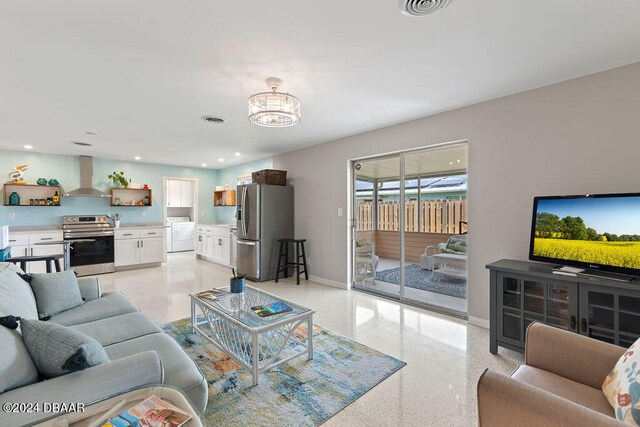 living room with an inviting chandelier and washer / clothes dryer