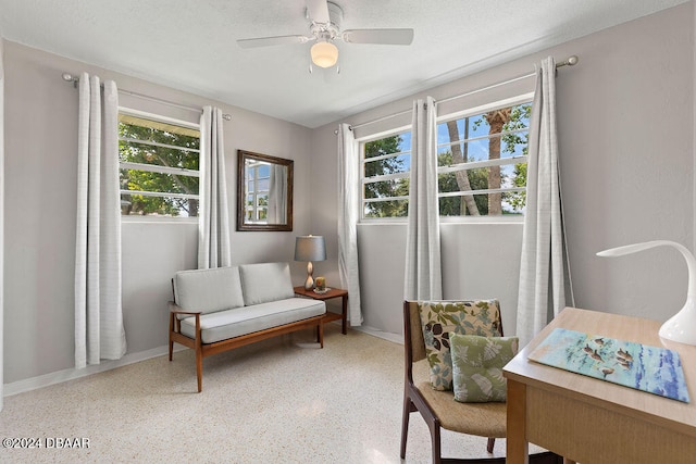 sitting room with ceiling fan, a healthy amount of sunlight, and a textured ceiling