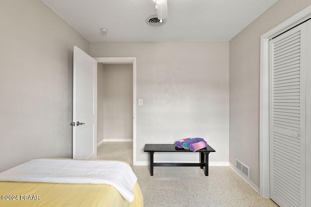 bedroom featuring a textured ceiling and a closet