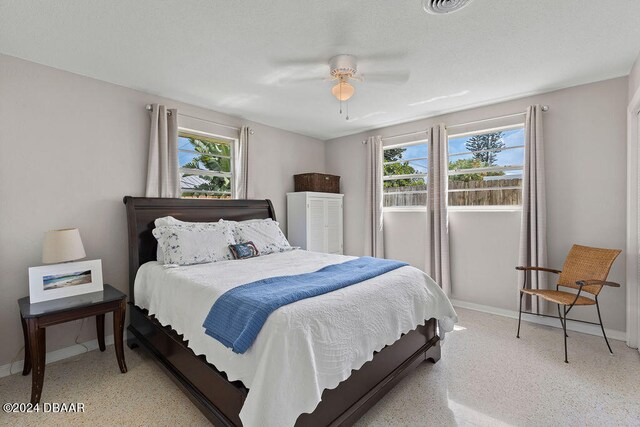 bedroom with ceiling fan and multiple windows