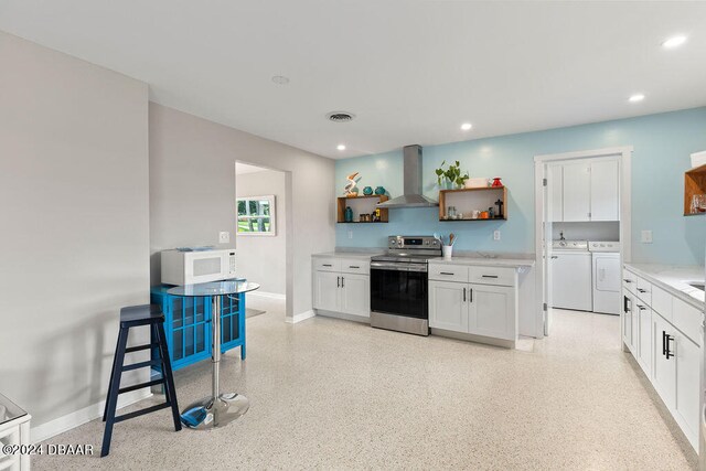 kitchen with white cabinets, separate washer and dryer, wall chimney exhaust hood, and stainless steel range with electric cooktop