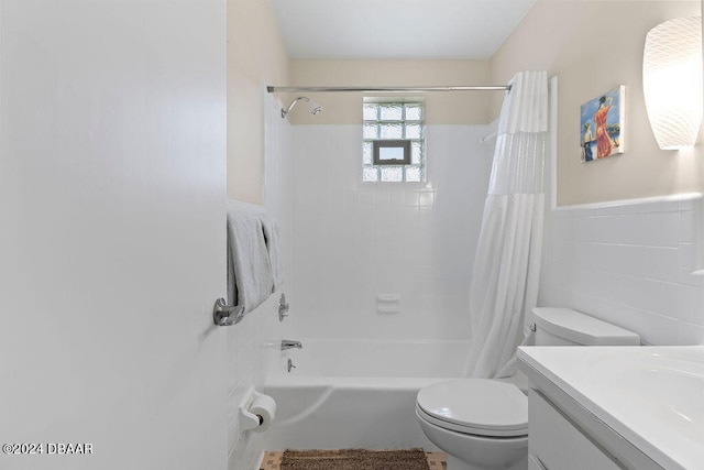 full bathroom with shower / bath combo, vanity, toilet, and tile walls