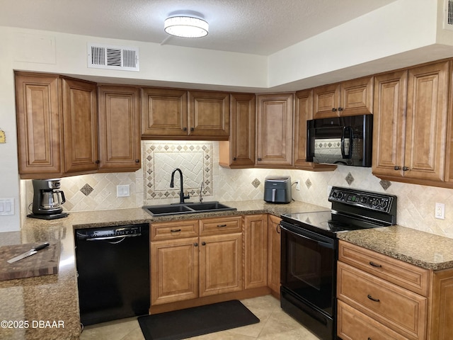 3580 S Ocean Shore Blvd Unit 905, Flagler Beach, FL 32136 - kitchen with black appliances, brown cabinets, decorative backsplash, stone counters, and light tile patterned floors