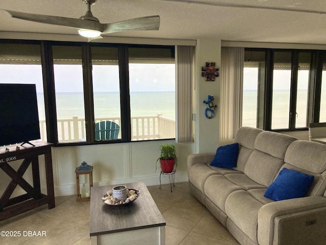 3580 S Ocean Shore Blvd Unit 905, Flagler Beach, FL 32136 - living room featuring plenty of natural light, light tile patterned flooring, a ceiling fan, and a water view