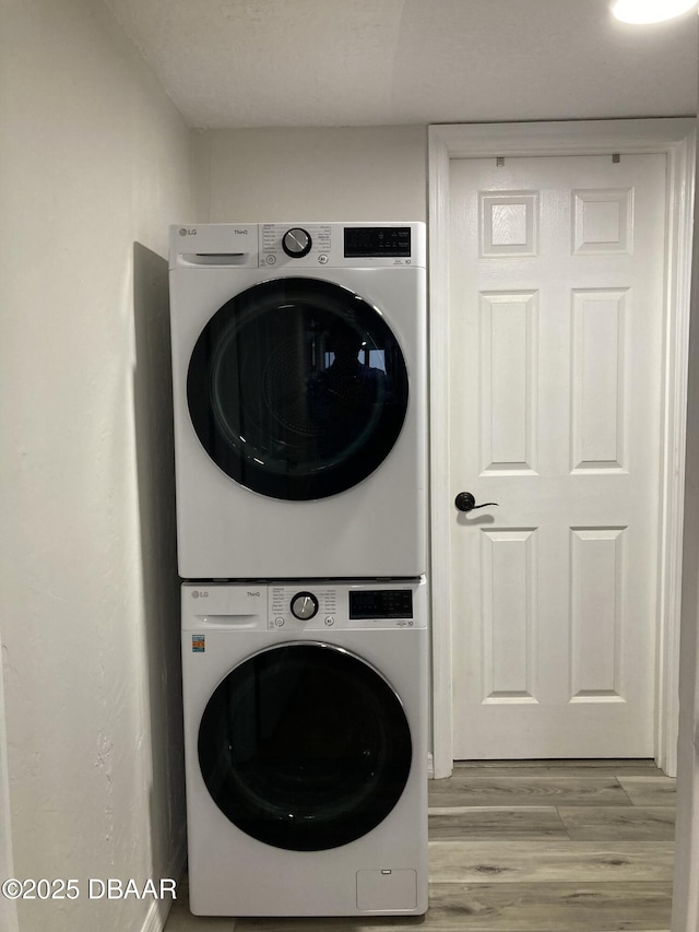 3580 S Ocean Shore Blvd Unit 905, Flagler Beach, FL 32136 - laundry room with stacked washing machine and dryer and light wood-style floors