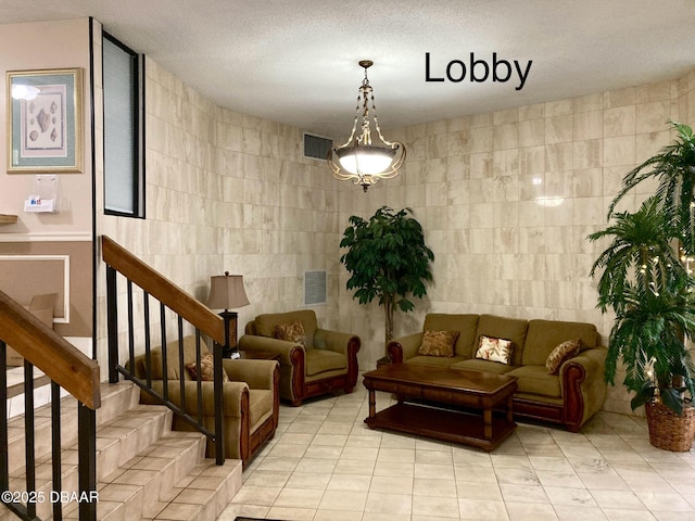 3580 S Ocean Shore Blvd Unit 905, Flagler Beach, FL 32136 - community lobby with tile walls, stairway, and a textured ceiling