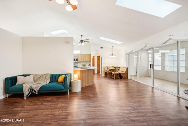 living room featuring sink, ceiling fan with notable chandelier, dark hardwood / wood-style floors, and vaulted ceiling with skylight