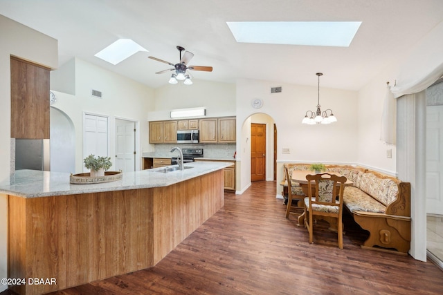 kitchen featuring kitchen peninsula, sink, pendant lighting, and dark hardwood / wood-style floors