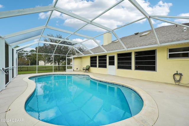 view of swimming pool featuring a patio and a lanai