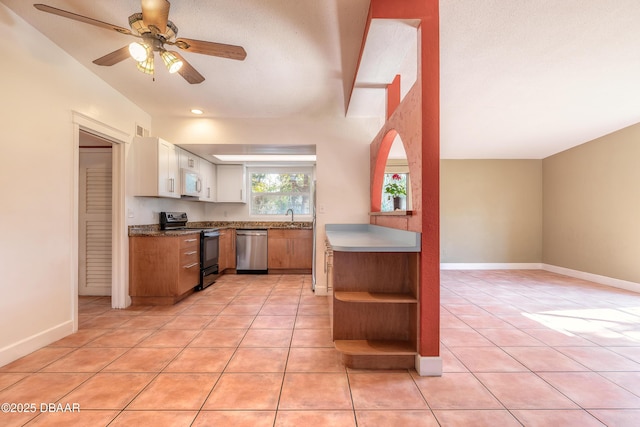 kitchen featuring ceiling fan, stainless steel dishwasher, black range with electric stovetop, light tile patterned floors, and white cabinets