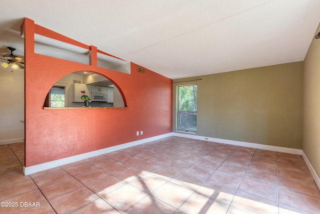 spare room with ceiling fan and light tile patterned flooring