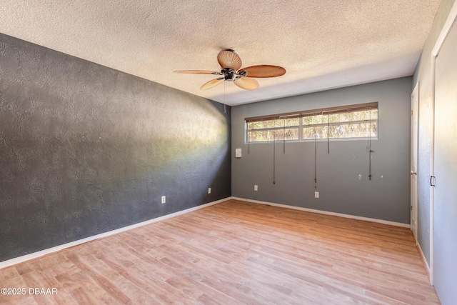 unfurnished room featuring ceiling fan, a textured ceiling, and light wood-type flooring