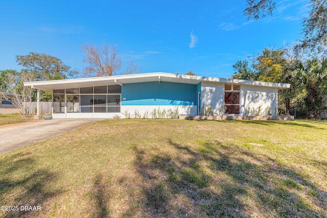 view of front of property with a front yard, a sunroom, and a carport