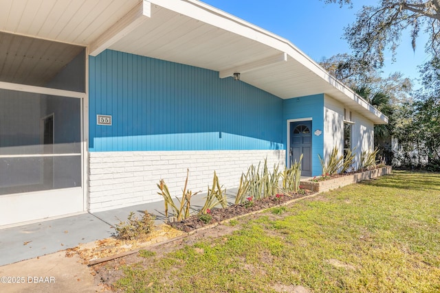 property entrance featuring a lawn