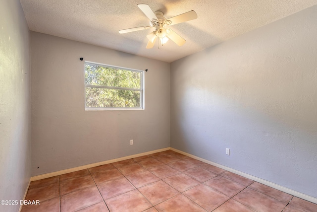 spare room with ceiling fan, light tile patterned floors, and a textured ceiling