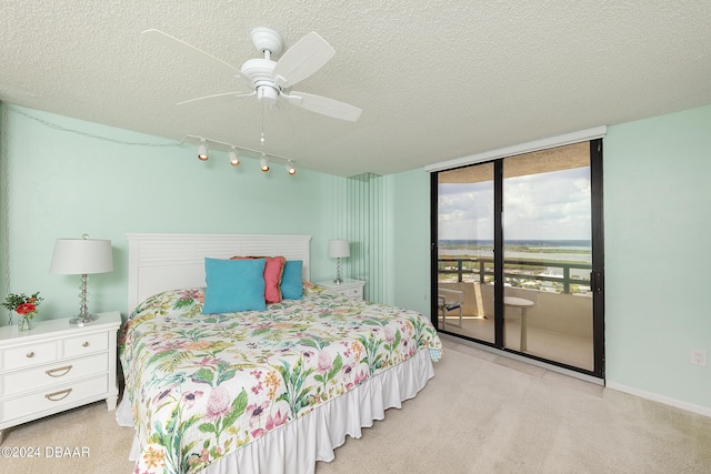 3855 S Atlantic Ave Unit 1206B, Daytona Beach Shores, FL 32118 - bedroom with access to outside, a textured ceiling, track lighting, floor to ceiling windows, and carpet floors