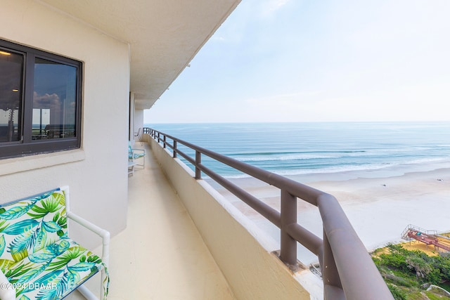 balcony featuring a water view and a beach view