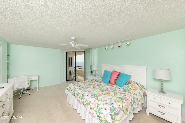 bedroom featuring a textured ceiling, light carpet, and ceiling fan