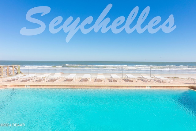 view of pool featuring a beach view and a water view