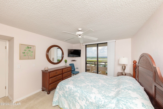 bedroom with light colored carpet, ceiling fan, a textured ceiling, and access to outside