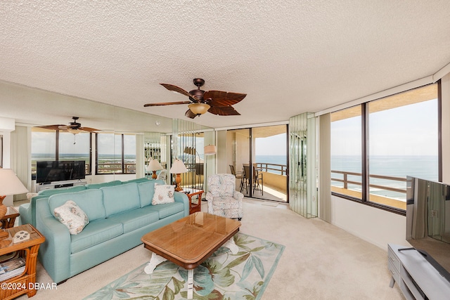 carpeted living room featuring a textured ceiling, a healthy amount of sunlight, and ceiling fan