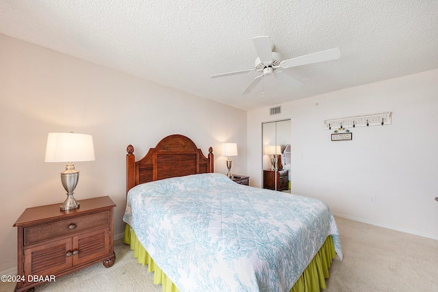 carpeted bedroom featuring ceiling fan, a textured ceiling, and a closet