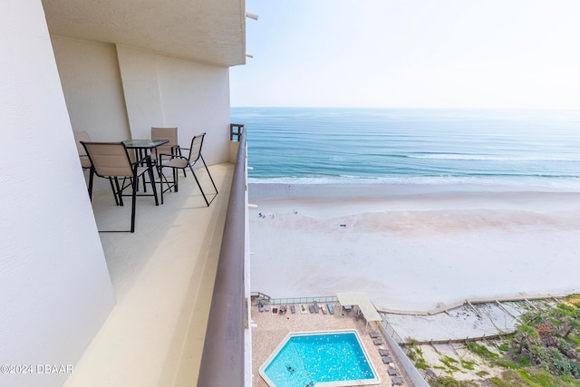 balcony featuring a water view and a view of the beach