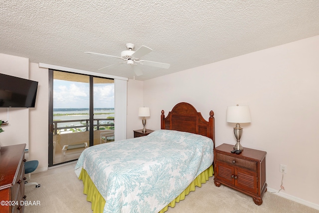 bedroom with ceiling fan, a textured ceiling, light carpet, and access to outside