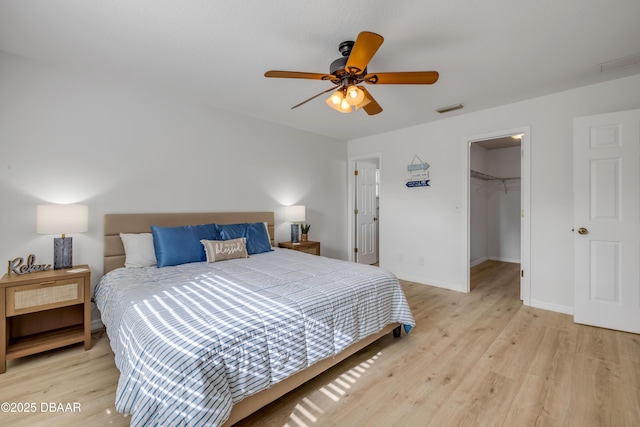 805 Spruce St, New Smyrna Beach, FL 32168 - bedroom featuring light wood finished floors, a walk in closet, a ceiling fan, and a closet