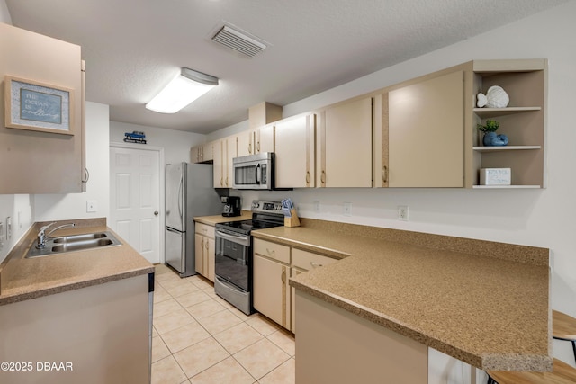805 Spruce St, New Smyrna Beach, FL 32168 - kitchen featuring stainless steel appliances, light countertops, a peninsula, light tile patterned flooring, and cream cabinets