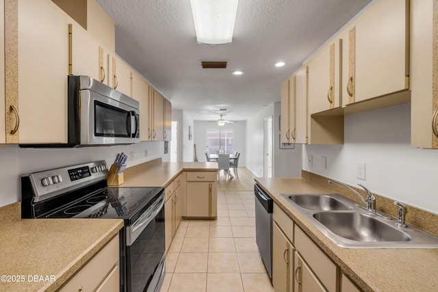 805 Spruce St, New Smyrna Beach, FL 32168 - kitchen featuring stainless steel appliances, cream cabinetry, light tile patterned floors, light countertops, and a peninsula