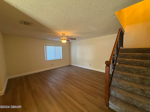 interior space with dark wood-type flooring, a textured ceiling, and ceiling fan