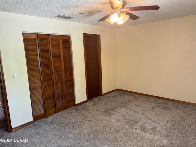 unfurnished bedroom with a textured ceiling, carpet flooring, and ceiling fan