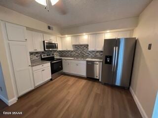 kitchen featuring white cabinetry, appliances with stainless steel finishes, ceiling fan, backsplash, and hardwood / wood-style floors