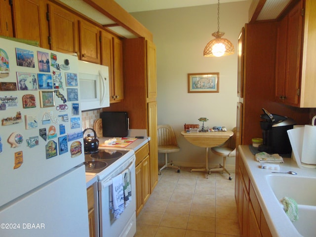 kitchen featuring hanging light fixtures, light tile patterned flooring, white appliances, and sink