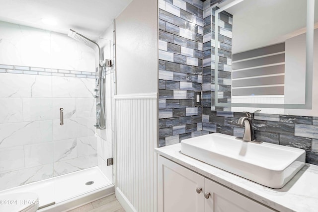 bathroom featuring a shower with shower door, vanity, and toilet