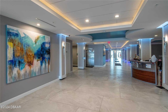 hallway with a raised ceiling