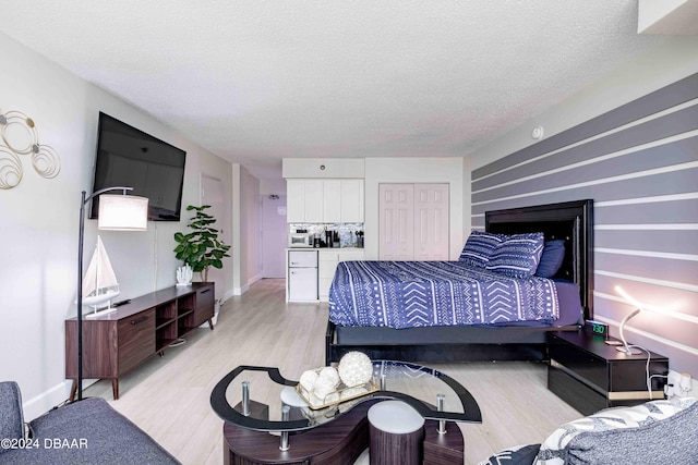 bedroom with light hardwood / wood-style floors and a textured ceiling