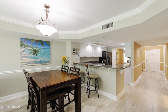 4650 Links Village Dr Unit C-505, Ponce Inlet, FL 32127 - dining space with crown molding, light wood-style floors, and baseboards