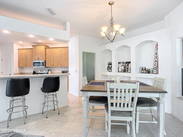 kitchen featuring pendant lighting, light tile patterned flooring, kitchen peninsula, and an inviting chandelier